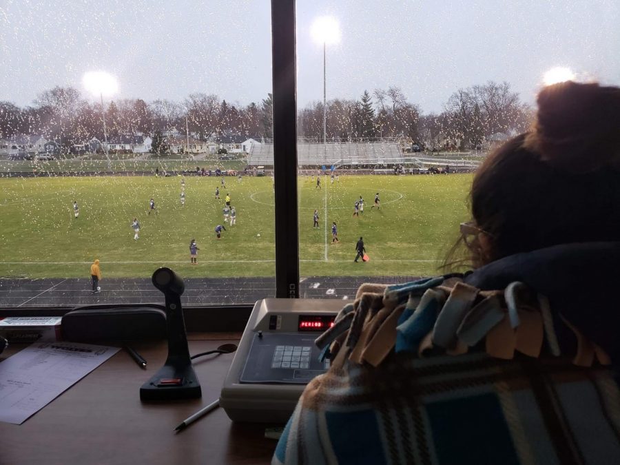 %0AAn+overall+picture+with+a+close+up+of+the+scorekeeper+and+in+the+background+the+varsity+game+taking+place.%0A