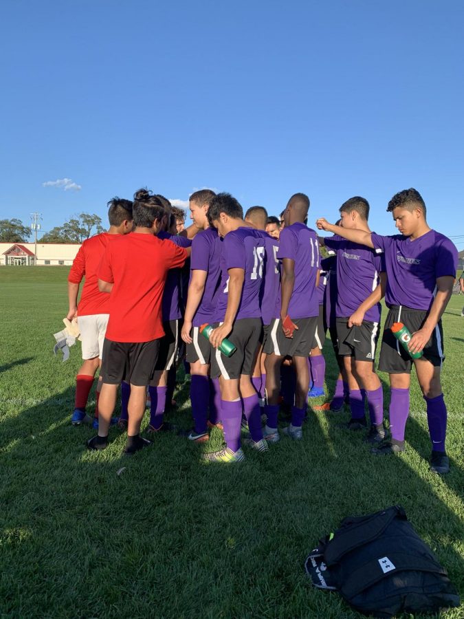 The+soccer+team+huddles+up+before+a+game+this+season.