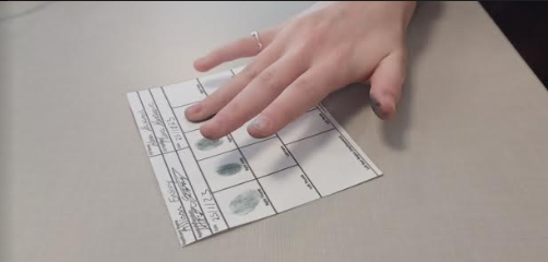 Human placing Right Ring fingerprint on CSI FInger Identification sheet.